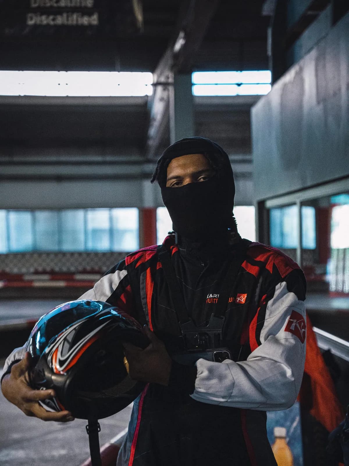 Samuel Tavenaux en tenue de karting, casque à la main, dans le hall de la piste